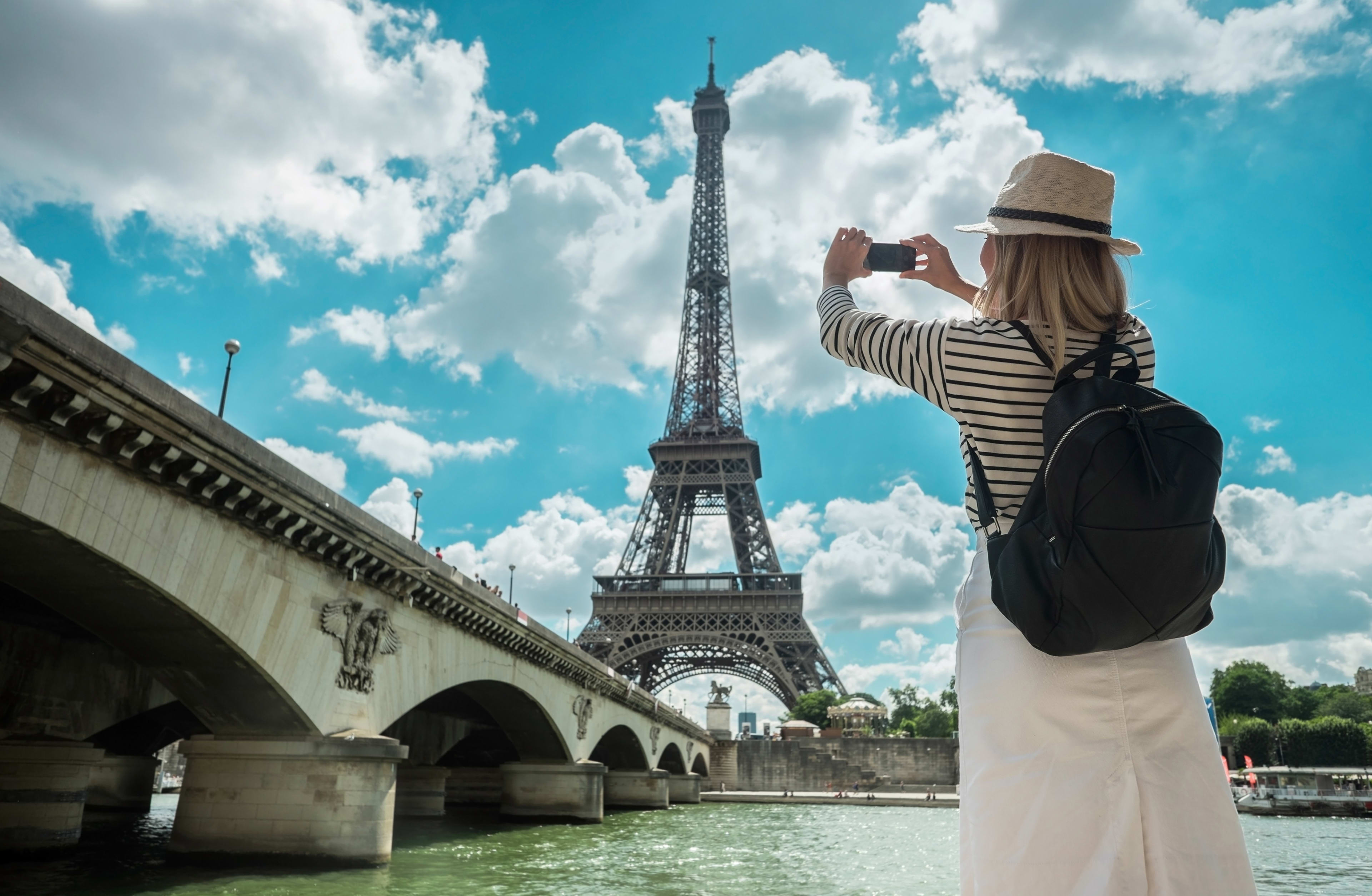 Woman taking selfie in front of the Eiffel Tower