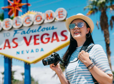 Woman taking photos at the iconic 'Welcome to Fabulous Las Vegas' sign