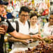 Cookery class students browsing for fresh ingredients at a Thai food market.