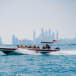 Speedboat cruising against the Dubai skyline at sunset.