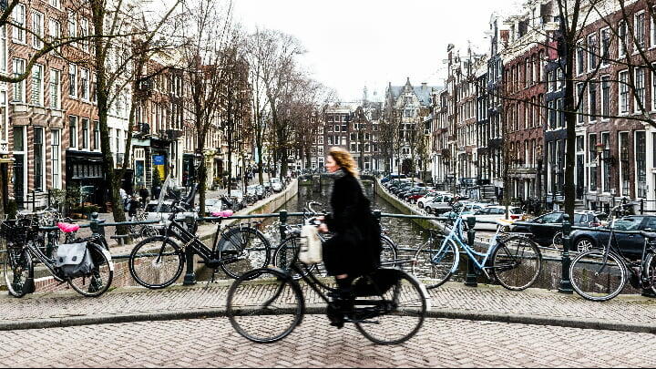 Image of Adult, Female, Person, Woman, Bicycle, Vehicle, Cycling, Cityscape, Urban, Car, Bag, Handbag, Wheel, 