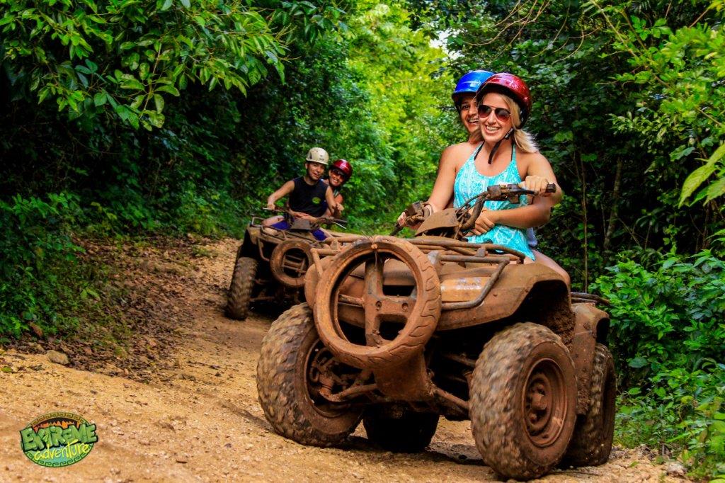 Image of Vegetation, Jungle, Nature, Outdoors, Helmet, Tree, Land, Woodland, Person, Photography, Portrait, Rainforest, Glove, Adult, Male, Man, Female, Woman, Atv, Vehicle, Accessories, Glasses, Wheel, 