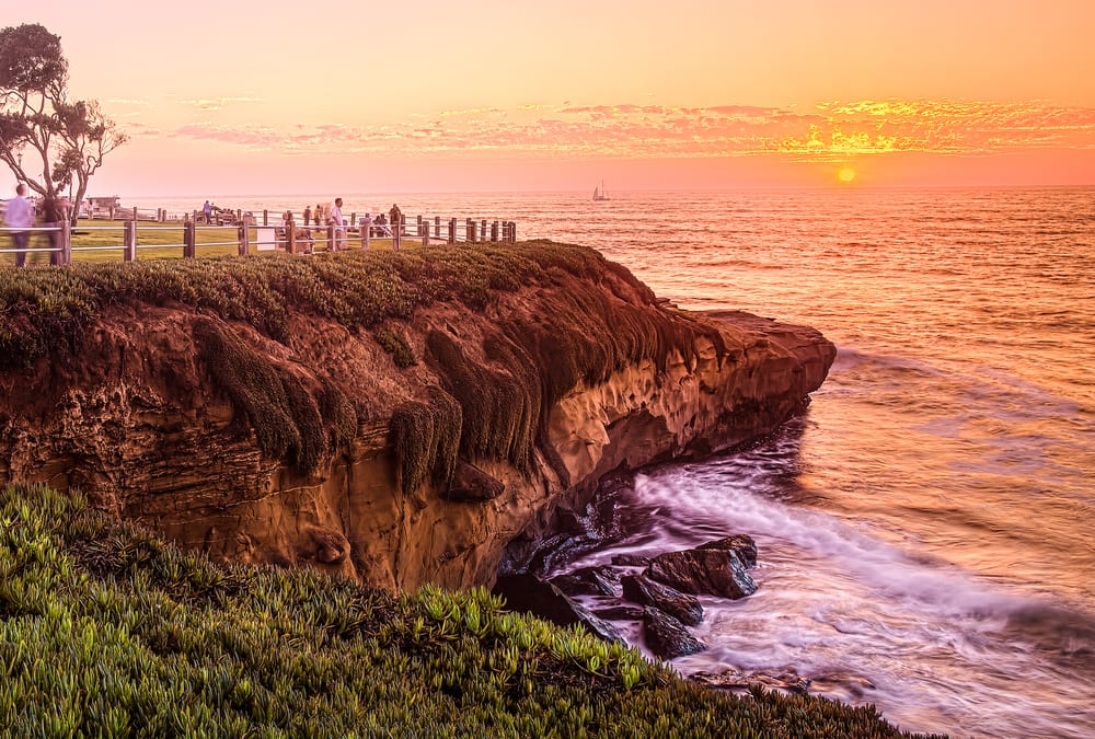 Image of Nature, Outdoors, Scenery, Sky, Cliff, Person, Sea, Water, Sunset, Landscape, Boat, Promontory, Bear, 