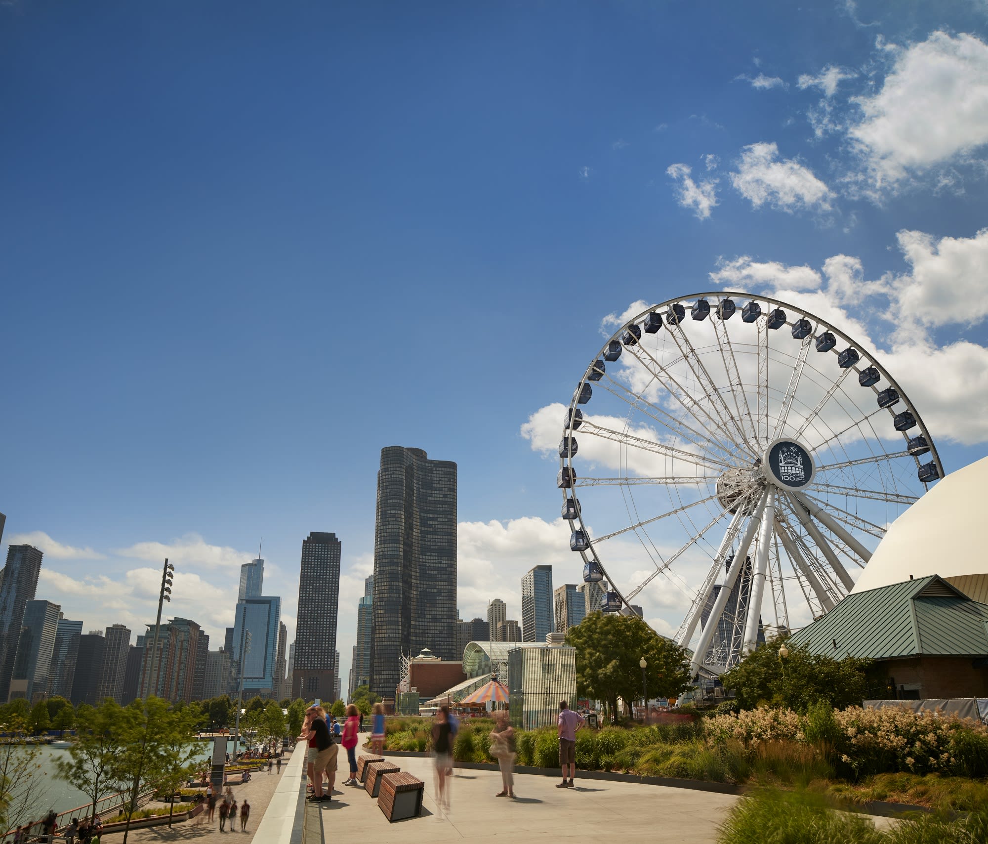 Image of City, Metropolis, Urban, Wheel, High Rise, Cityscape, Grass, Nature, Outdoors, Park, Amusement Park, Ferris Wheel, Fun, Person, Photography, 