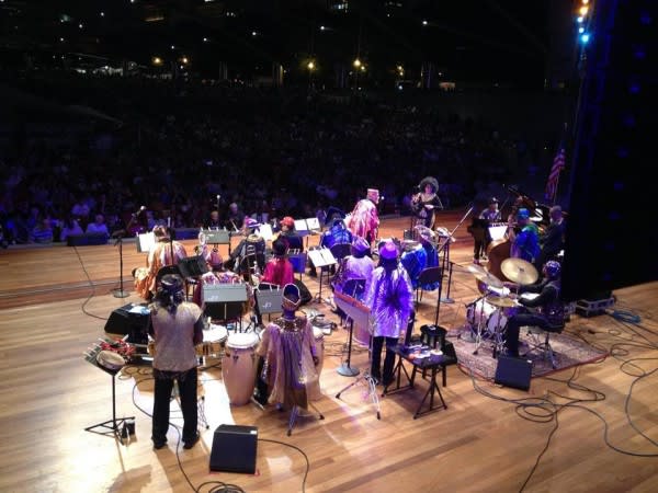 Image of Lighting, Concert, Crowd, Person, Adult, Female, Woman, Shoe, Group Performance, Music, Music Band, Musical Instrument, Musician, Performer, Speaker, Rug, Helmet, Stage, Desk, 