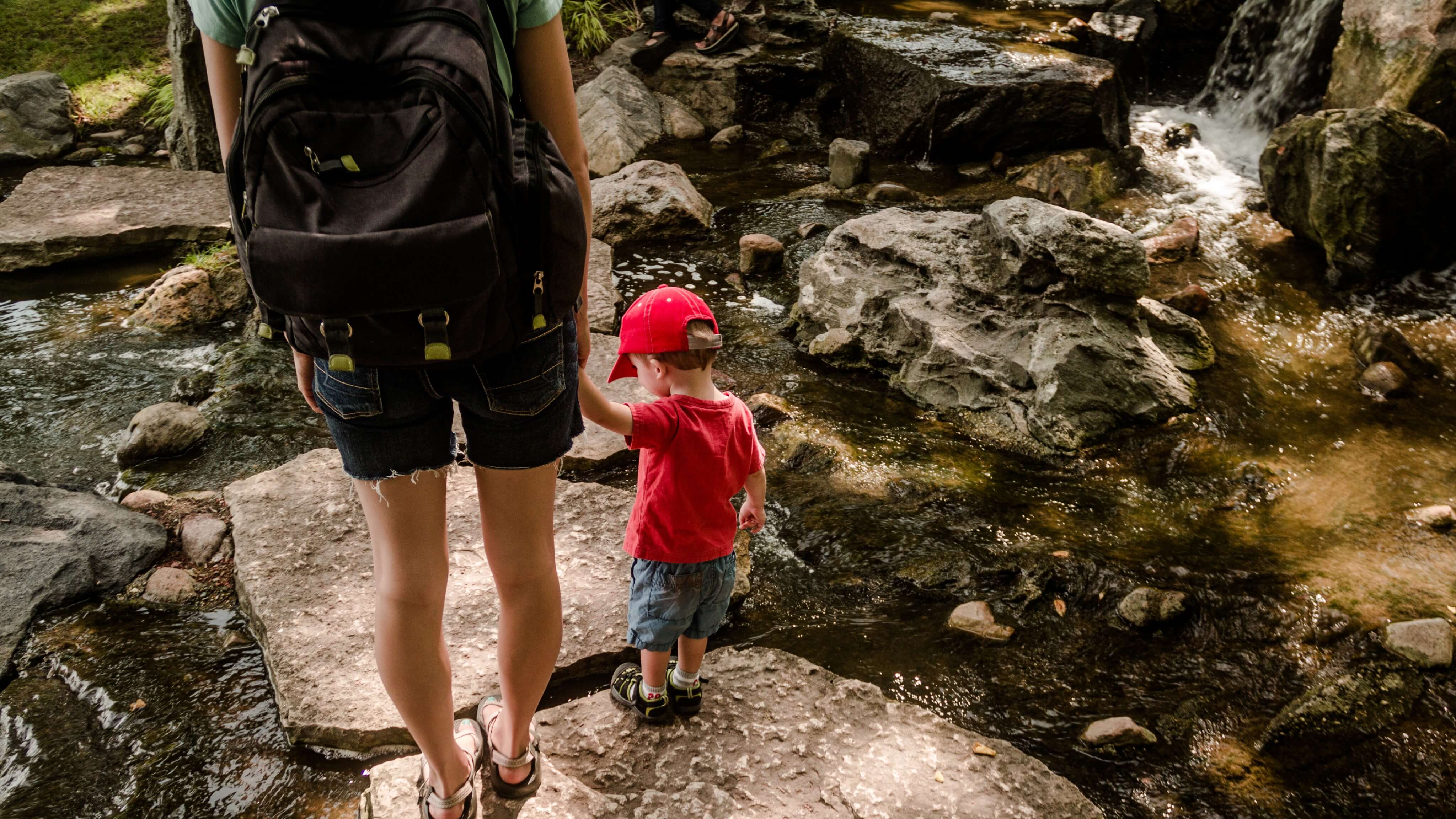 Image of Rock, Adventure, Hiking, Nature, Outdoors, Person, Shorts, Photography, Bag, Backpack, Baseball Cap, Cap, Hat, Boy, Child, Male, Portrait, Vegetation, Shoe, Water, 