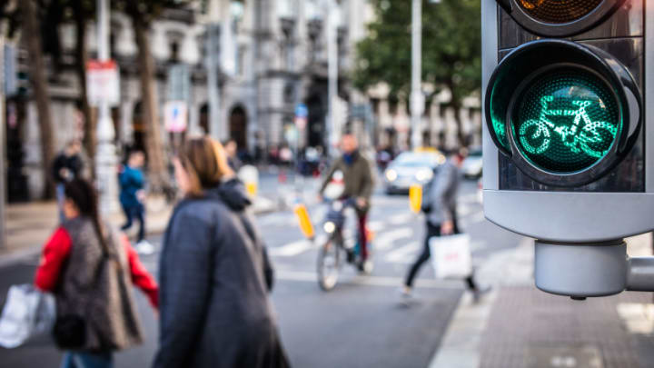 Image of Light, Person, Walking, Adult, Female, Woman, Traffic Light, Pedestrian, Bag, Handbag, Male, Man, Car, Bicycle, Coat, 