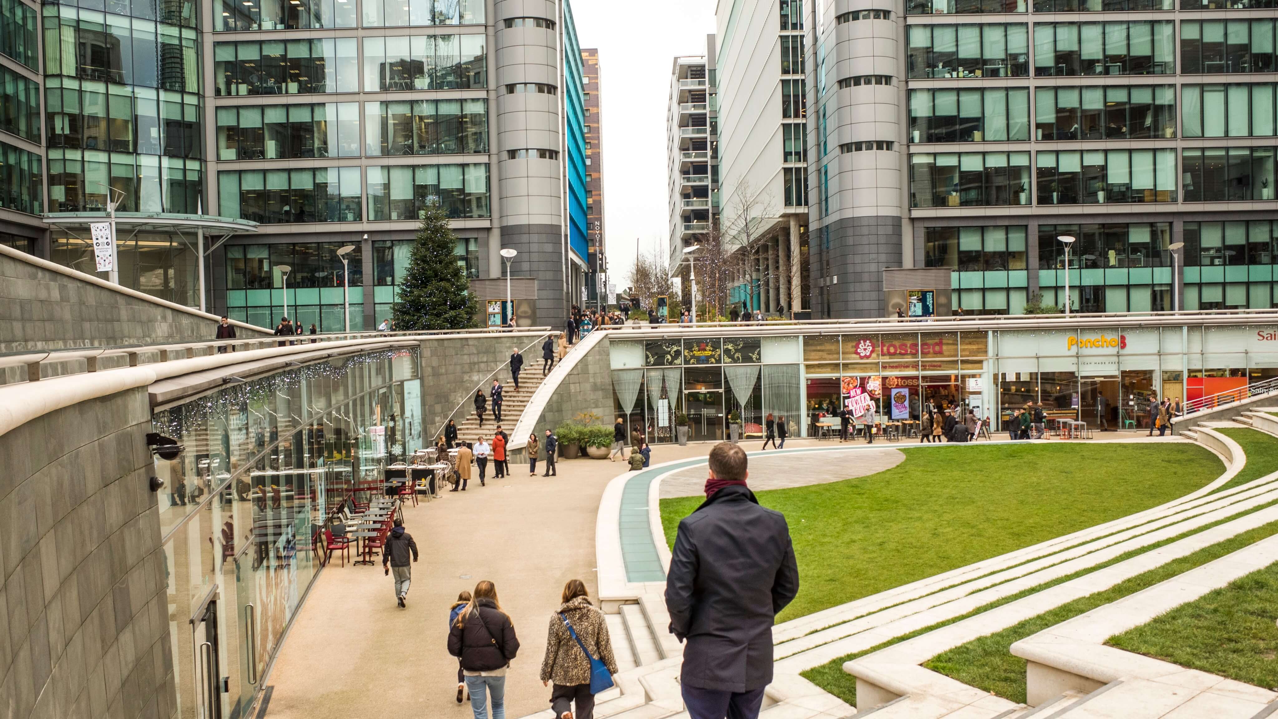 Image of City, Person, Walking, Urban, Handbag, Adult, Male, Man, Office Building, Plant, Path, Shop, Shopping Mall, Downtown, 