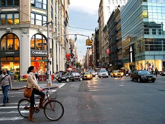 Image of City, Road, Street, Urban, Neighborhood, Metropolis, Bag, Handbag, Adult, Female, Person, Woman, Shoe, Car, Vehicle, Bicycle, Light, Traffic Light, 