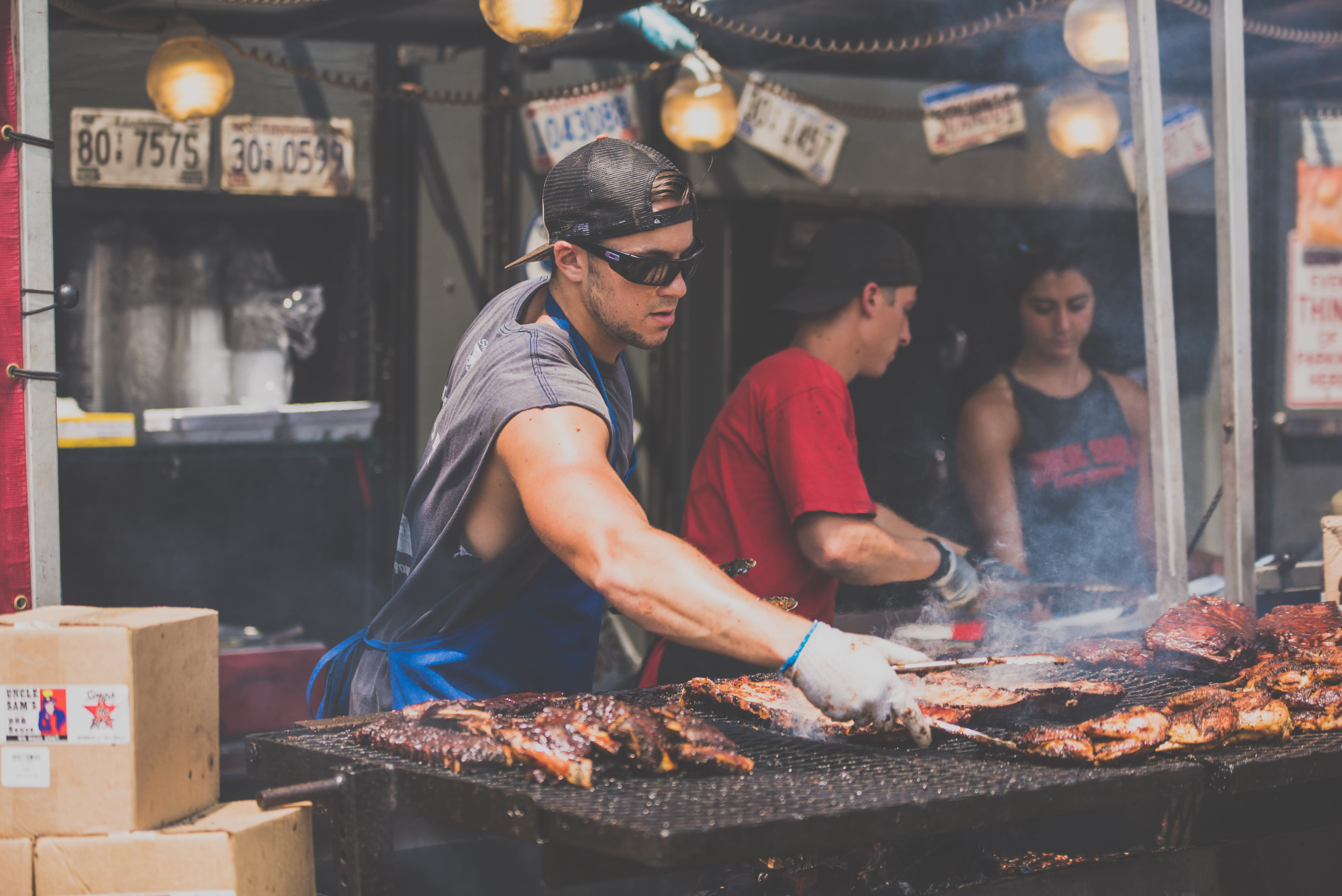 Image of Bbq, Cooking, Food, Grilling, Adult, Male, Man, Person, Glove, Female, Woman, Box, Hat, Bracelet, Glasses, Lamp, 