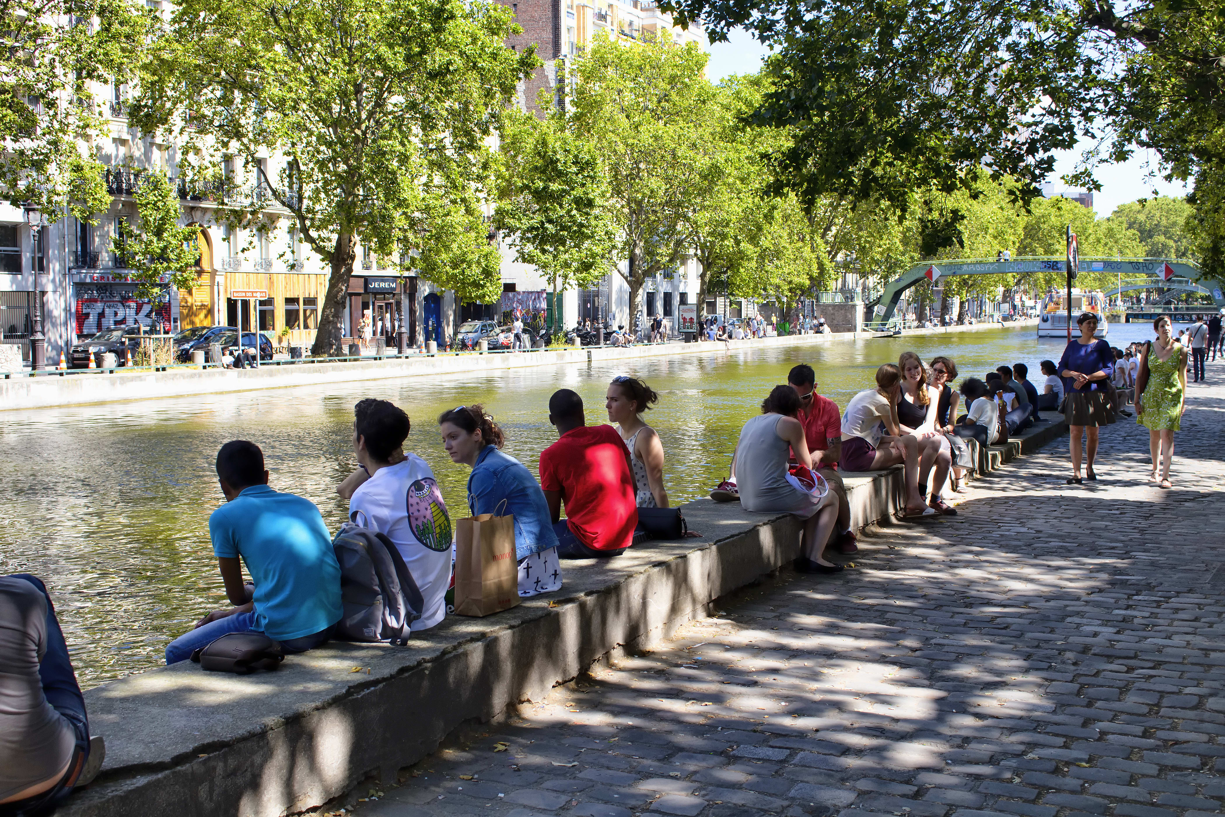 Image of Path, Sidewalk, Nature, Outdoors, Scenery, Walkway, Adult, Male, Man, Person, Female, Woman, Handbag, Canal, Water, Road, Car, Backpack, Back, Waterfront, City, Cobblestone, Urban, 