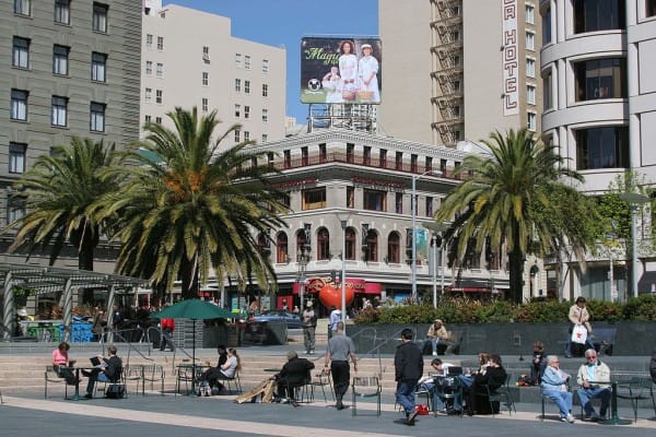 Image of City, Urban, Road, Street, Metropolis, Downtown, Shop, Shopping Mall, Handbag, Person, Tree, Chair, Furniture, Neighborhood, Car, Vehicle, Laptop, Shoe, Palm Tree, Bench, 