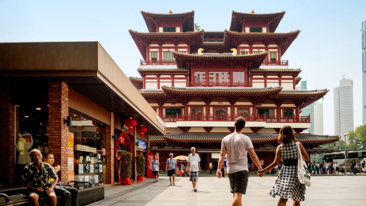 Image of City, Temple, Prayer, Shrine, Pagoda, Urban, Person, Walking, Adult, Male, Man, Female, Woman, Shorts, Bag, Handbag, 