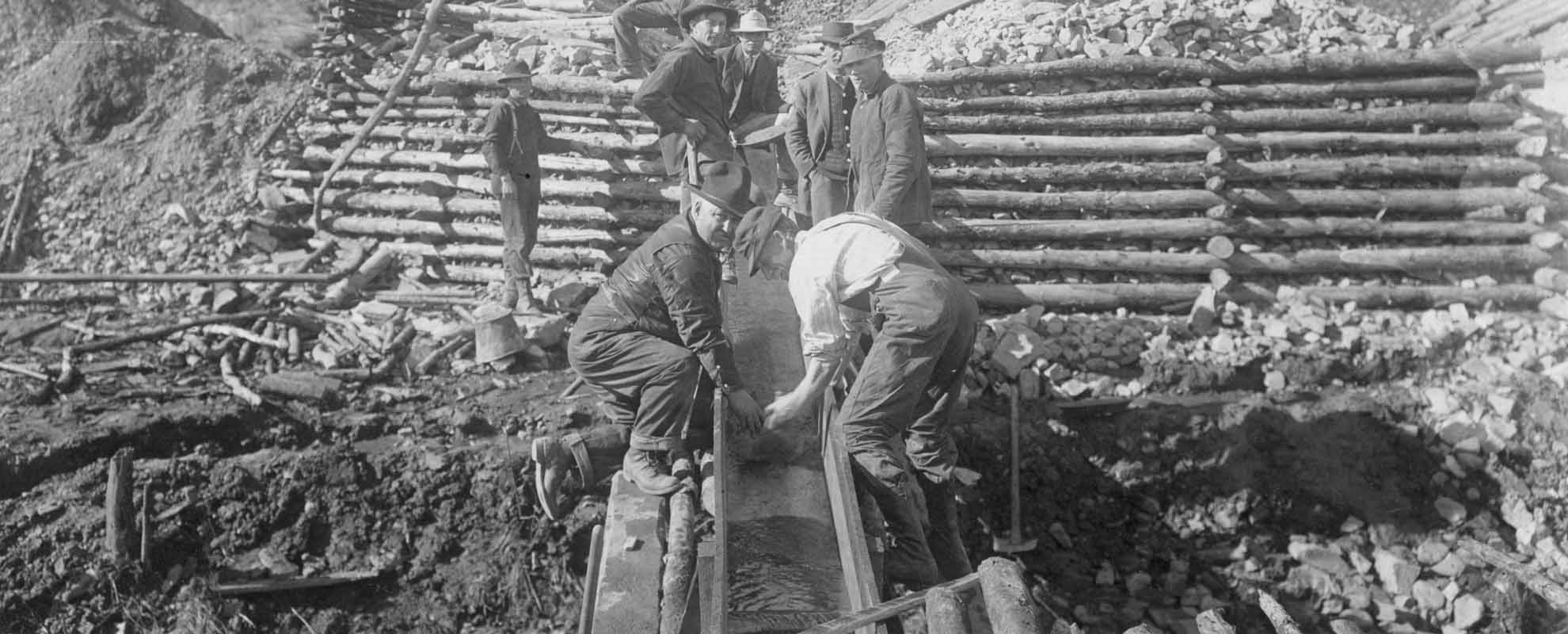 Prospectors using a gold sluice at a historic gold rush site