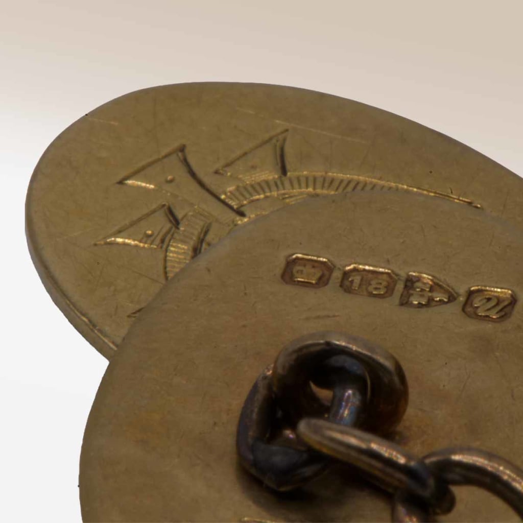 A close-up photo of an 18ct gold cufflink