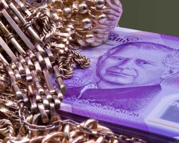 A pile of gold sitting on top of a stack of £20 notes
