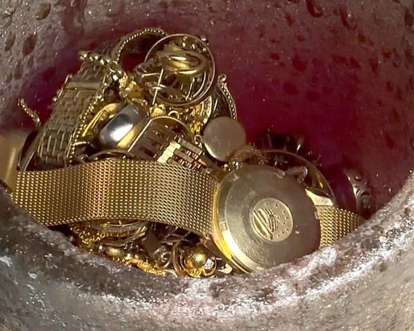 An Omega Constellation gold watch being melted in a crucible with a selection of scrap gold