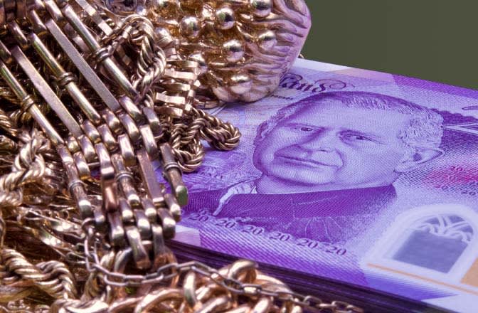 A pile of gold sitting on top of a stack of £20 notes