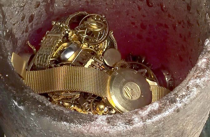 An Omega Constellation gold watch being melted in a crucible with a selection of scrap gold