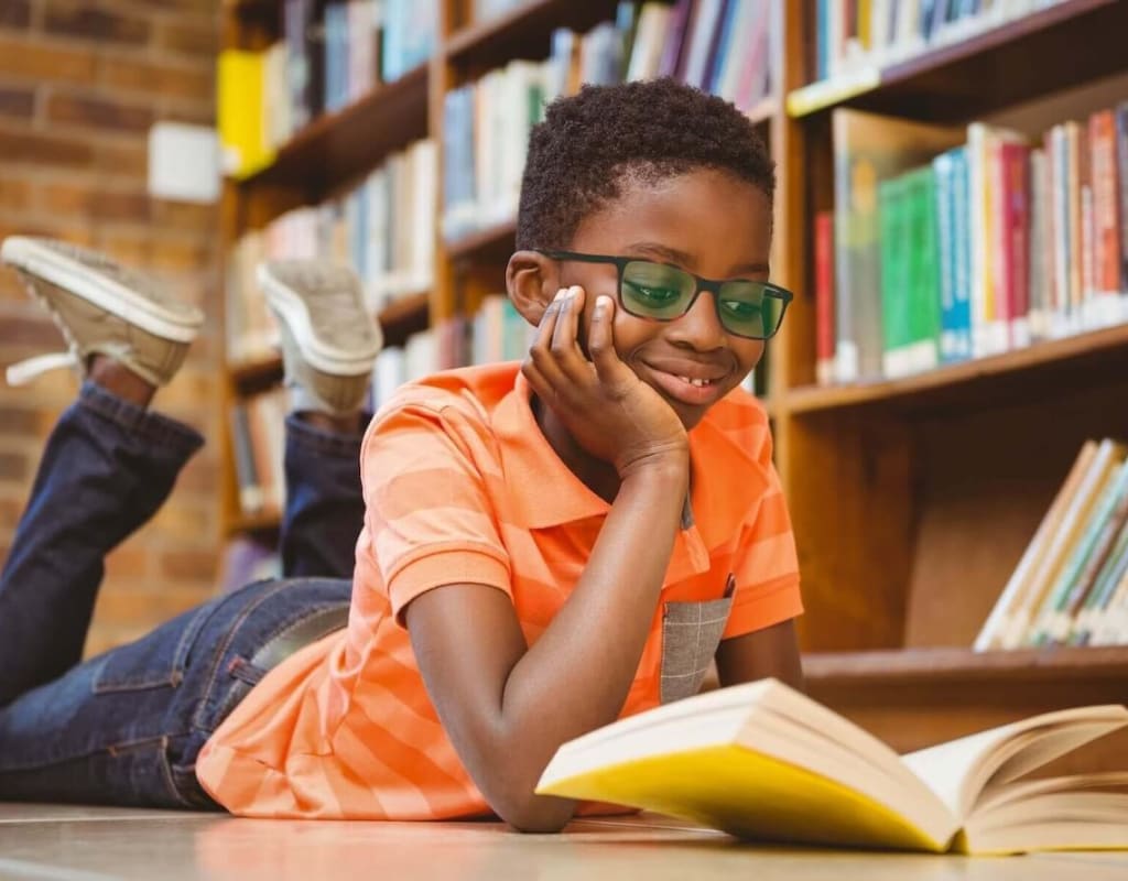 boy reading a book in school library