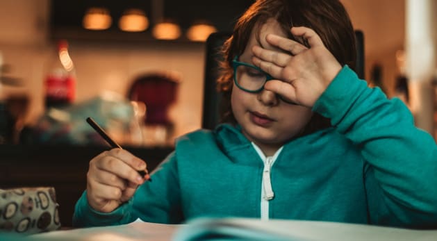 A boy struggling to do his homework