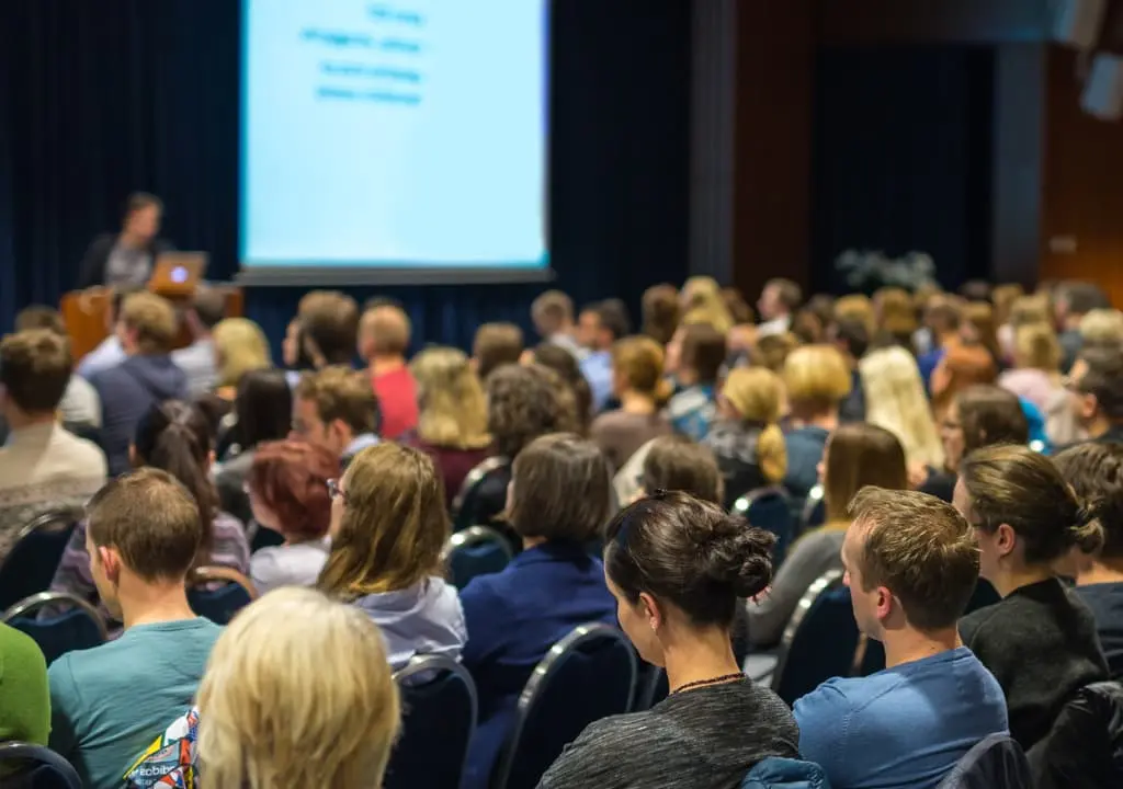 Image of a group of people listening to a presentation.