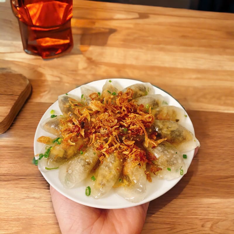 Đĩa bánh lọc trần rắc đầy hành phi cầm trên tay