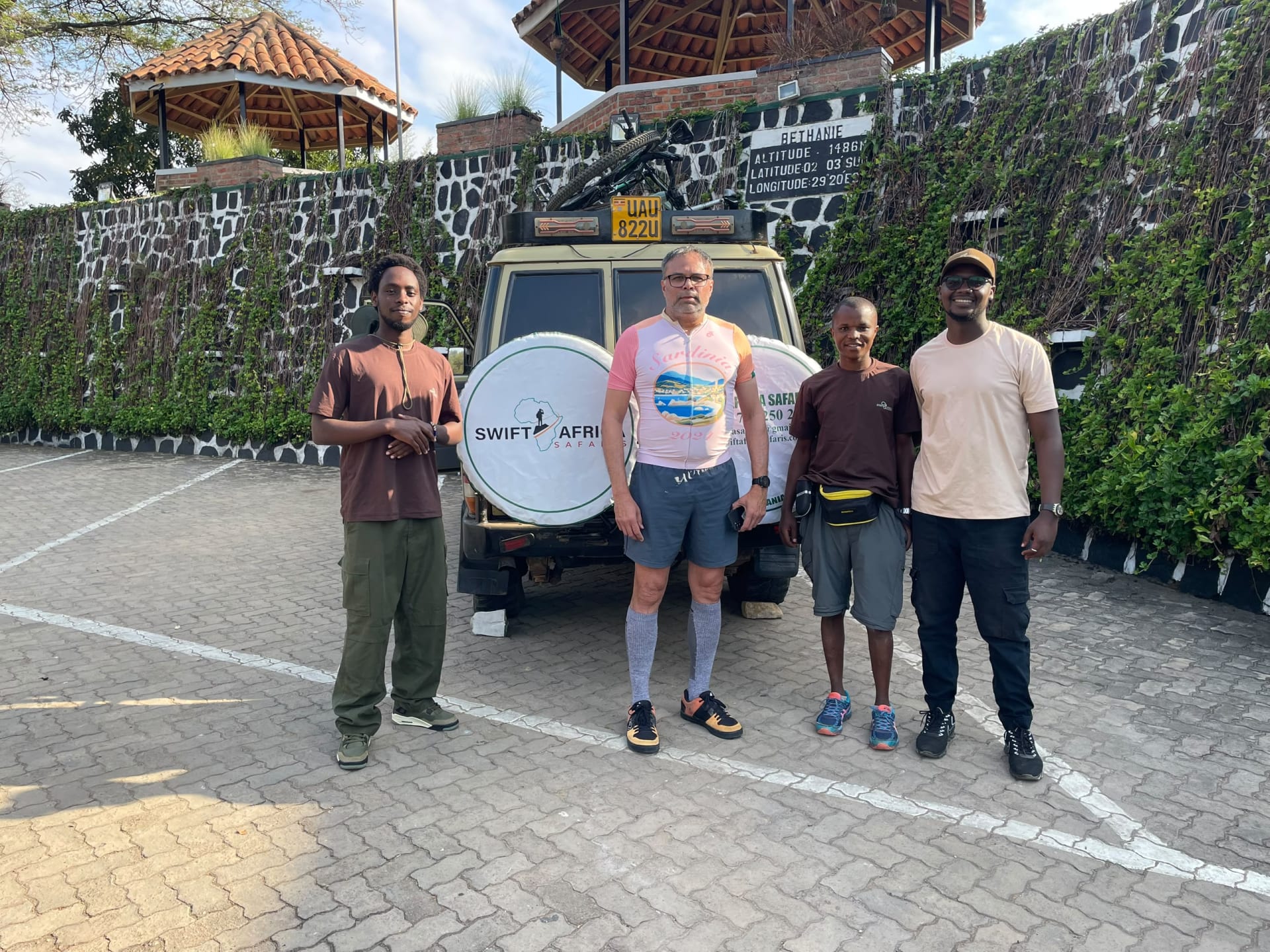 A Swift Africa Safaris vehicle and four guests at a lodge on the Congo Nile Trail route