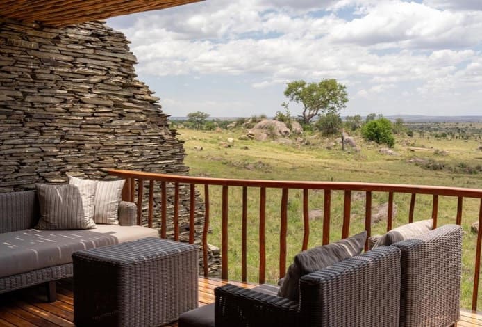 A lodge terrace with sofas looking out over the Serengeti plains
