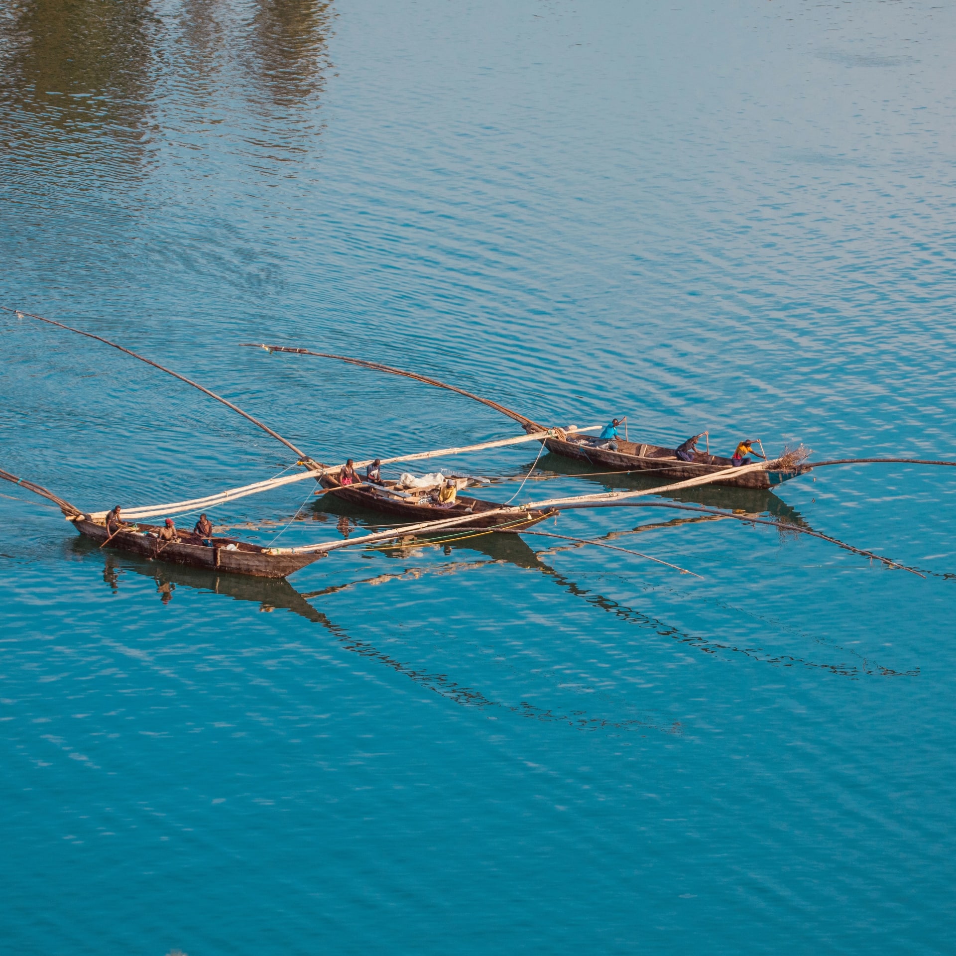 Traditional fishing boats with long outriggers on the turquoise water of Lake Kivu