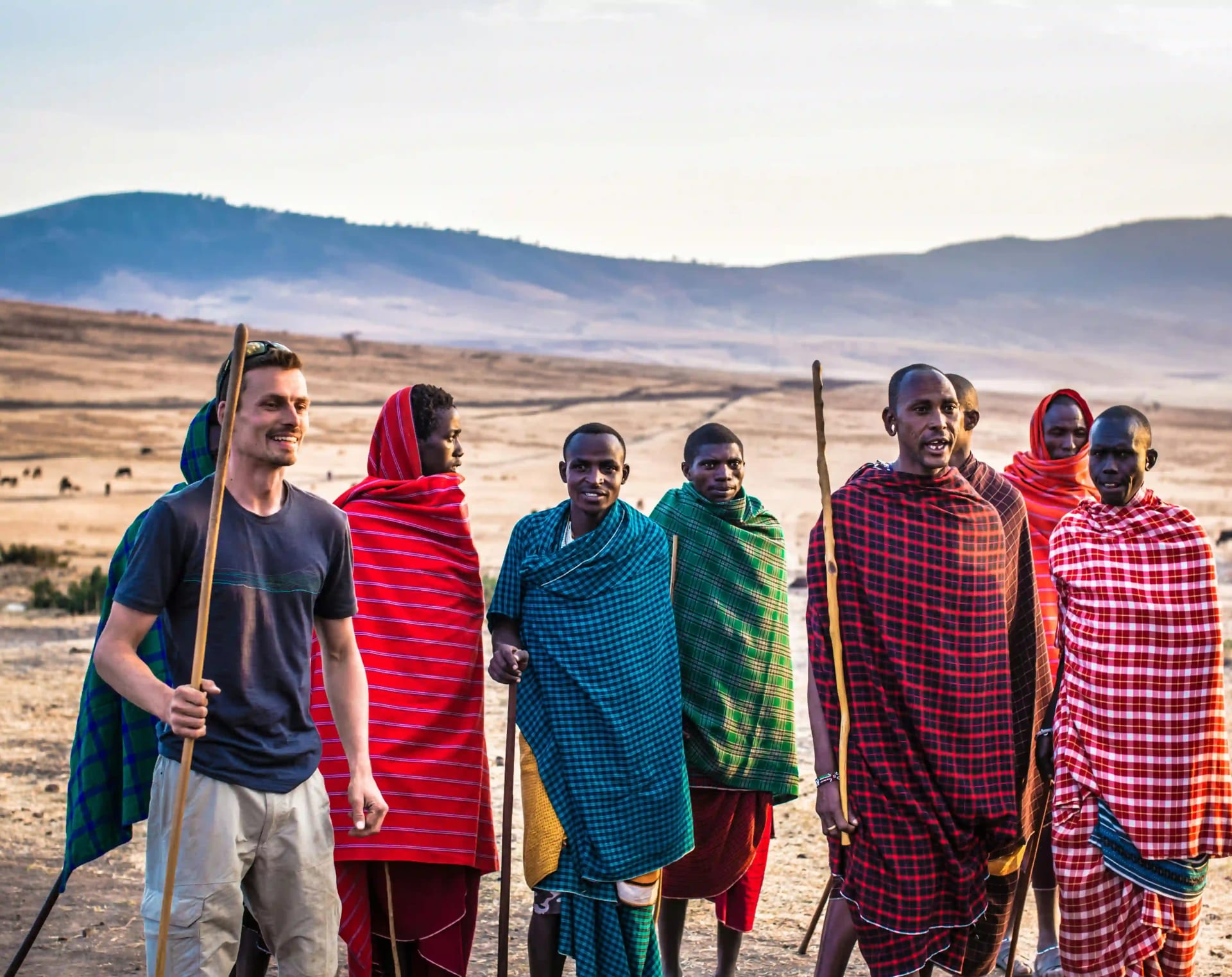 Maasai-Dörfler und Touristen singen und tanzen gemeinsam in einem traditionellen Maasai-Dorf, erleben lokale Kultur und Gemeinschaft.