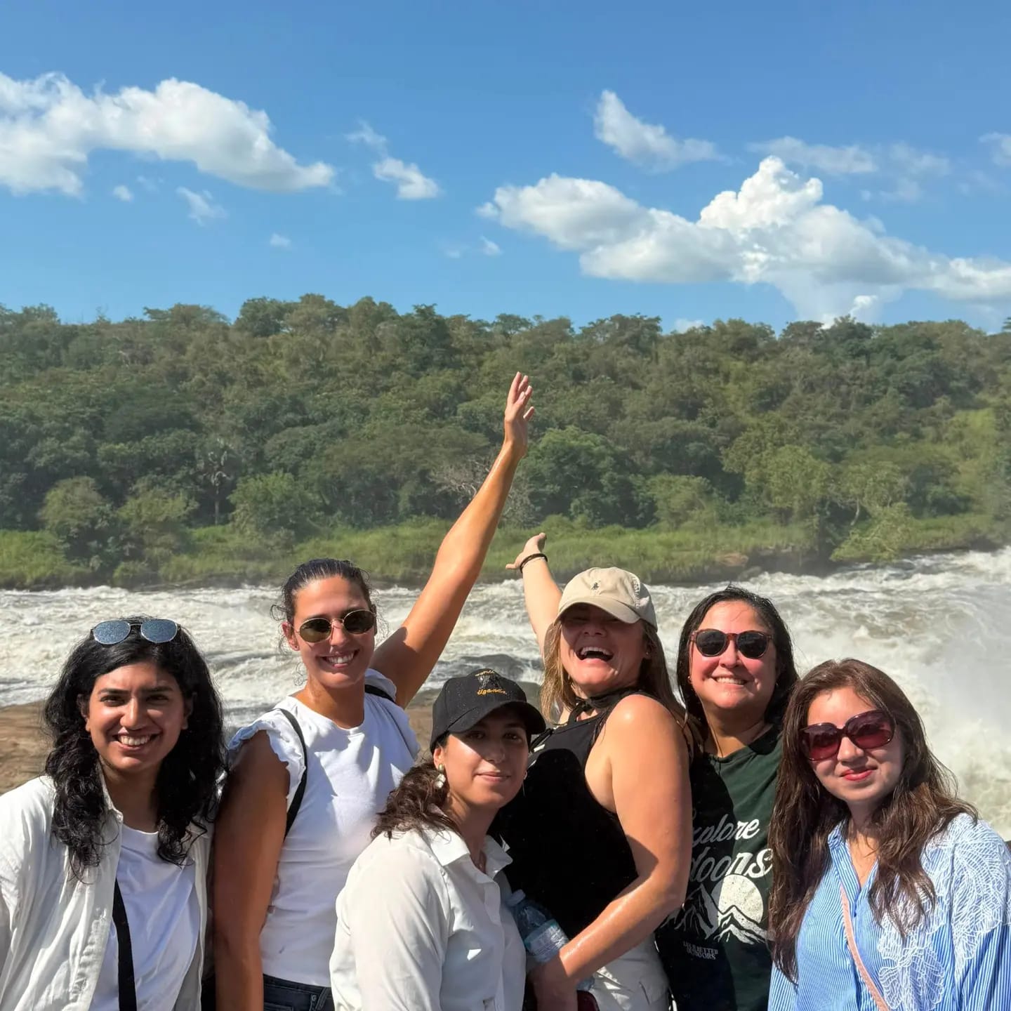 A group of visitors celebrating beside Murchison Falls on the Nile