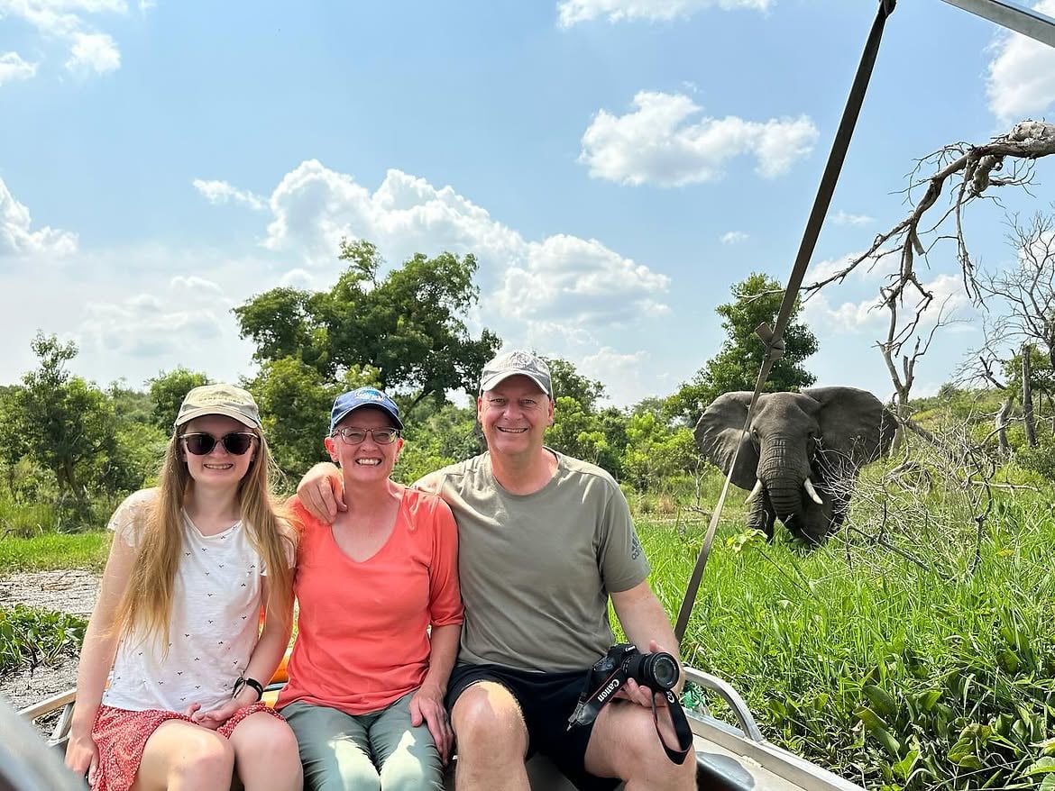 Three guests on a boat with an elephant on the river bank in Murchison Falls National Park