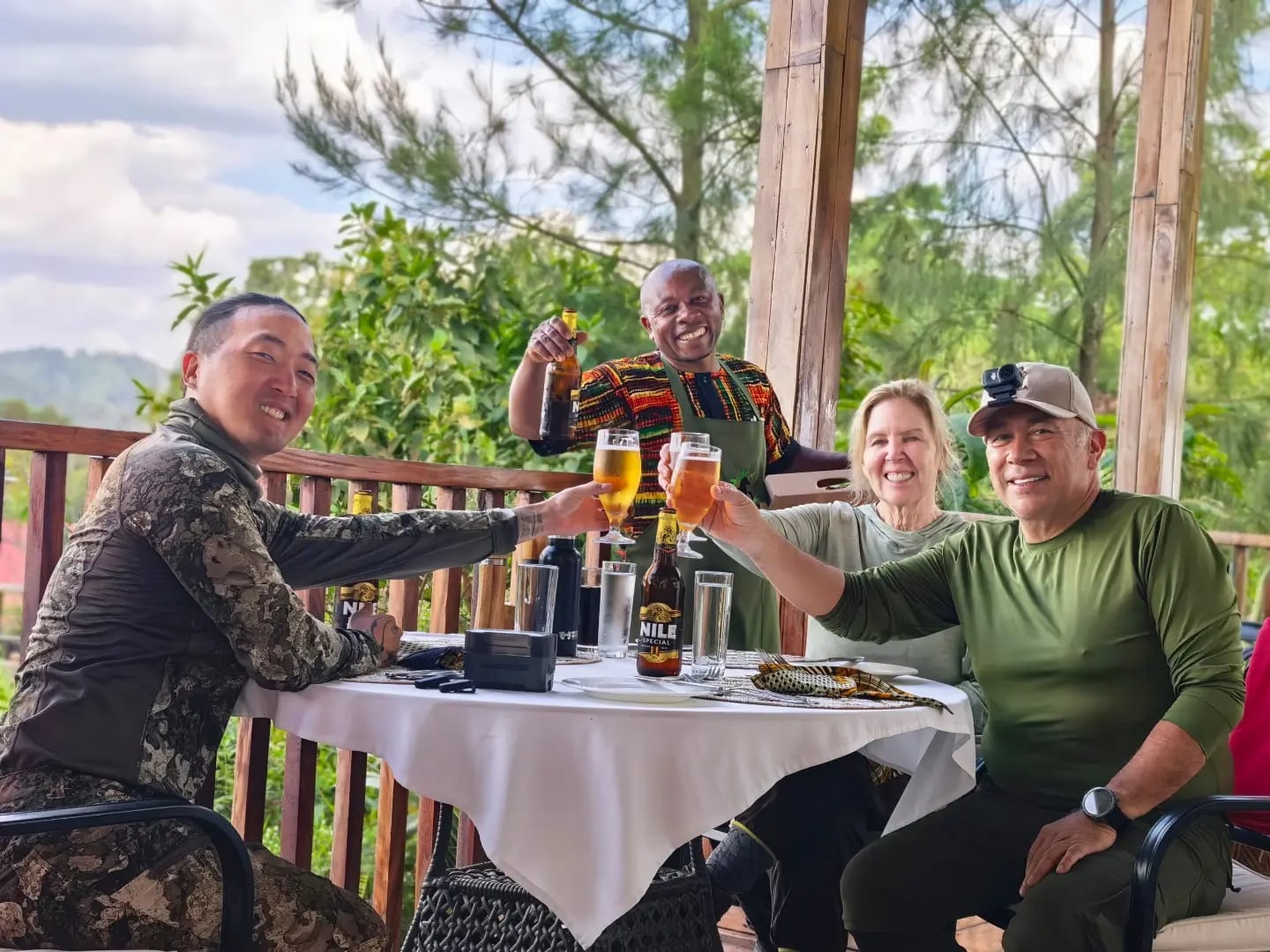 Four guests raising glasses on a lodge terrace