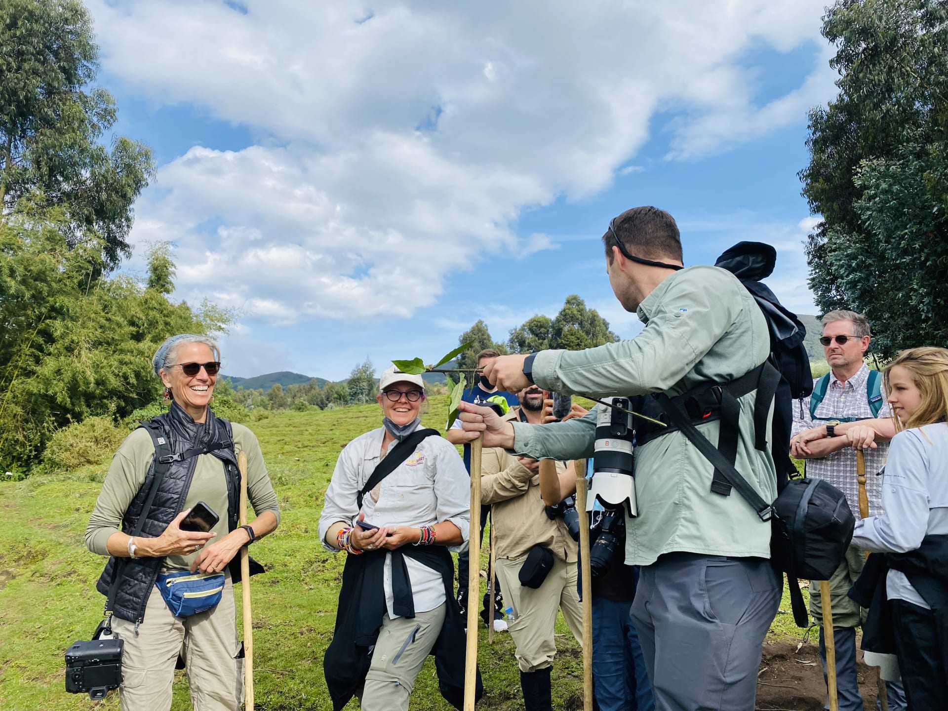 A group of trekkers and guides standing on grass before a trek in Volcanoes National Park