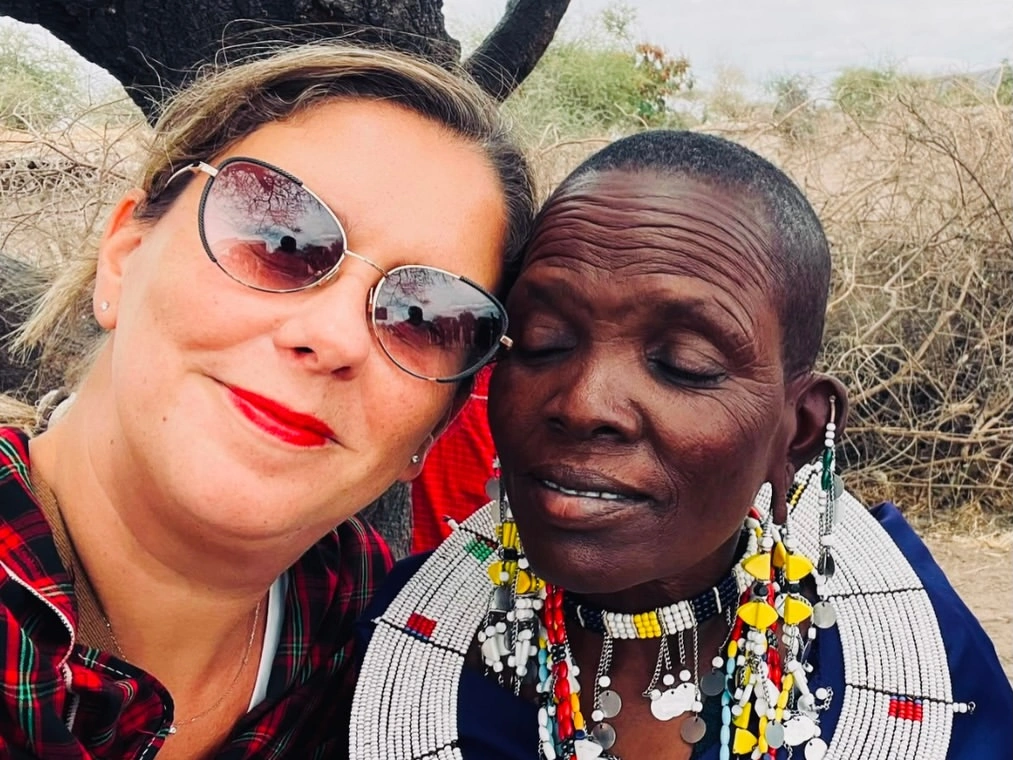 una viajera con una mujer maasai tomando un selfie