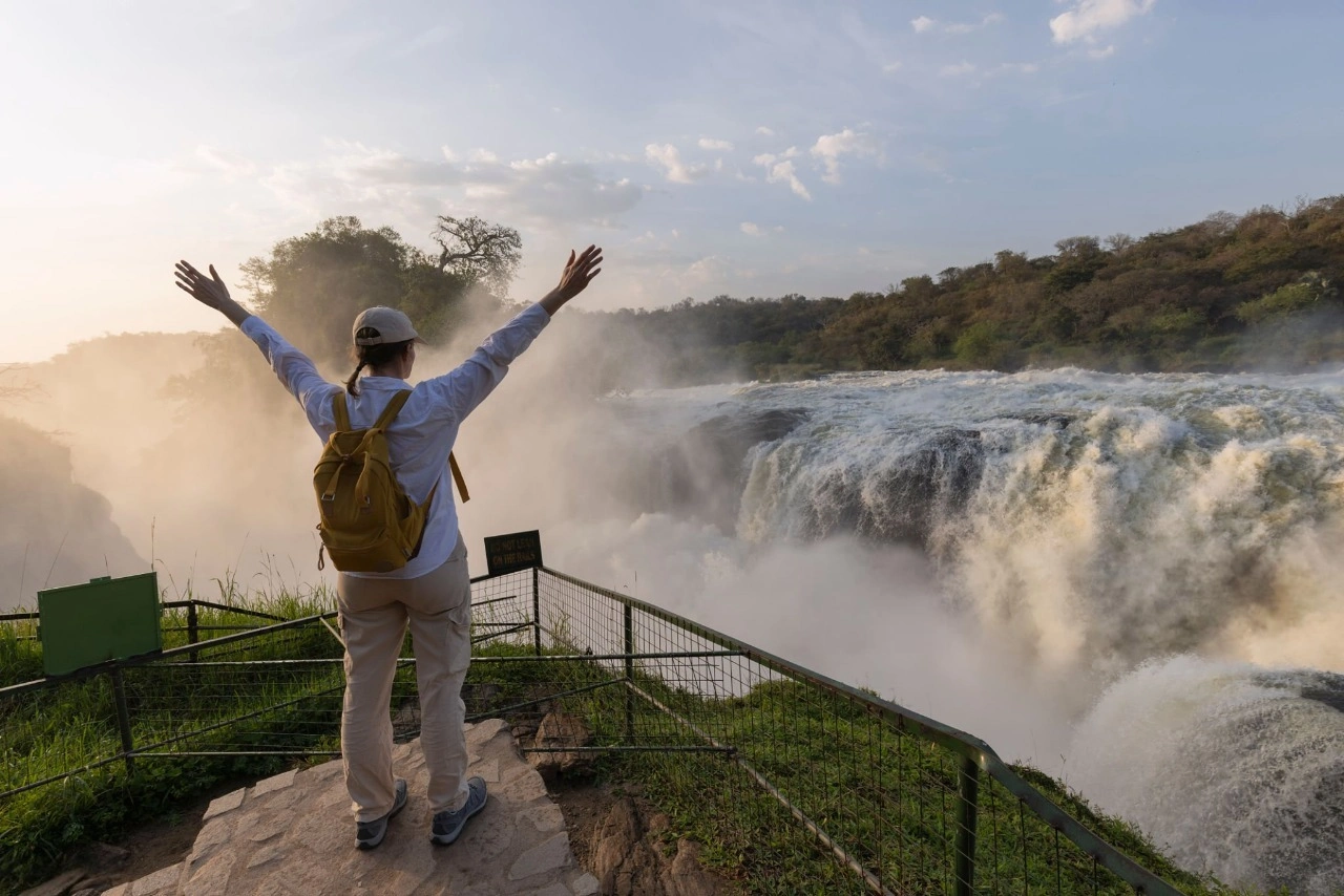 Reisender genießt die atemberaubende Aussicht und das donnernde Rauschen an der Spitze der Murchison Falls während einer 11-tägigen Uganda-Safari mit Gorilla‑Trekking, Schimpansen‑Tracking und Abenteuer im Murchison Falls Nationalpark.