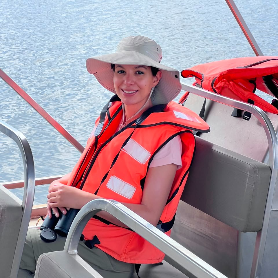 A woman in a sun hat and life jacket on a boat trip on a lake in Akagera National Park