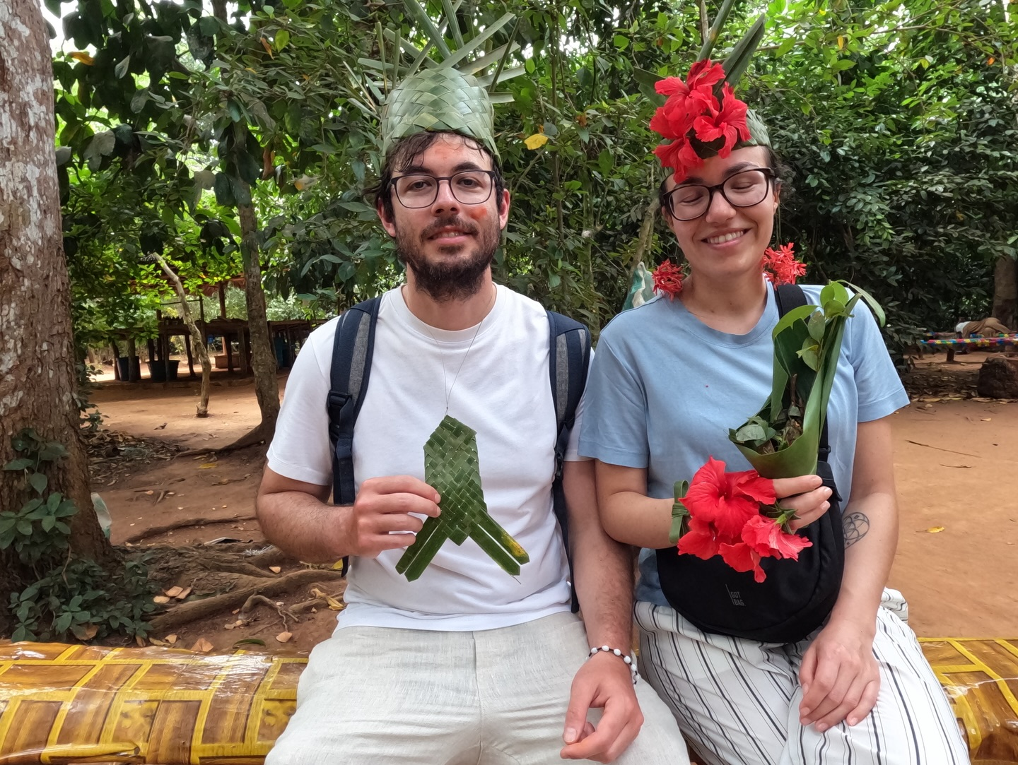 A couple holding leaf crafts and flowers during a spice farm visit on Zanzibar