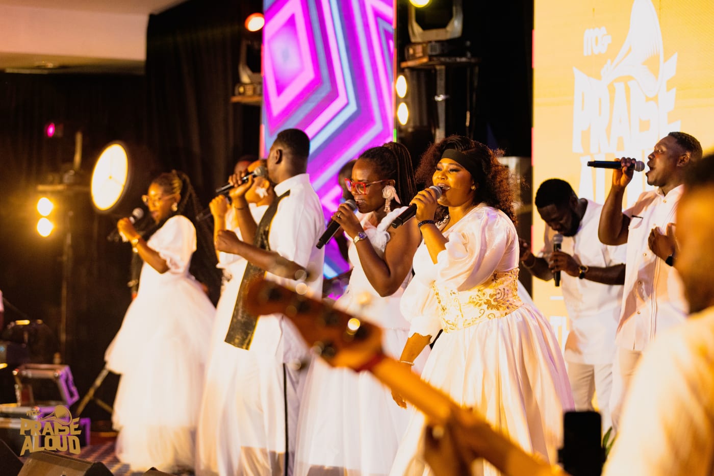The MOGmusic worship team in white, singing together on stage