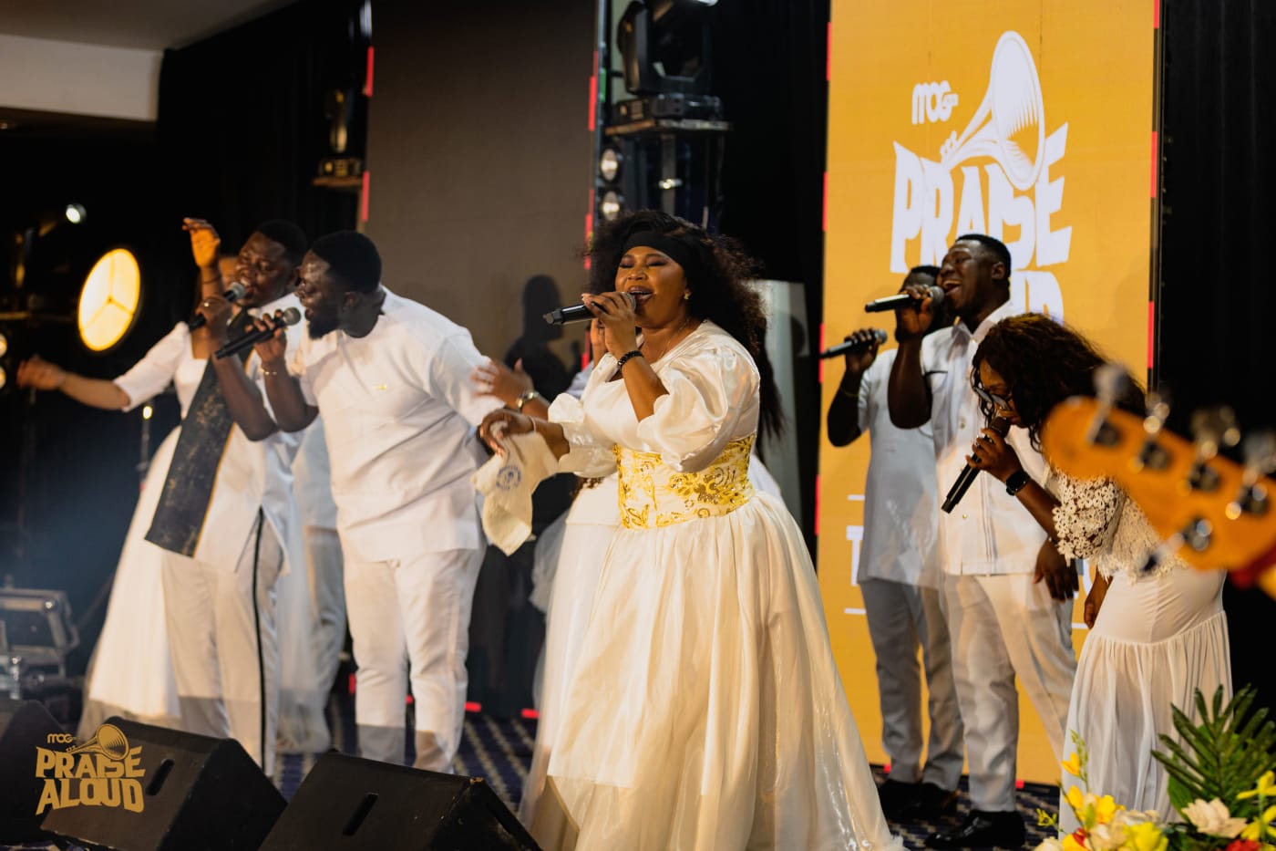 Singers dressed in white leading worship on stage at MOG Praise Aloud