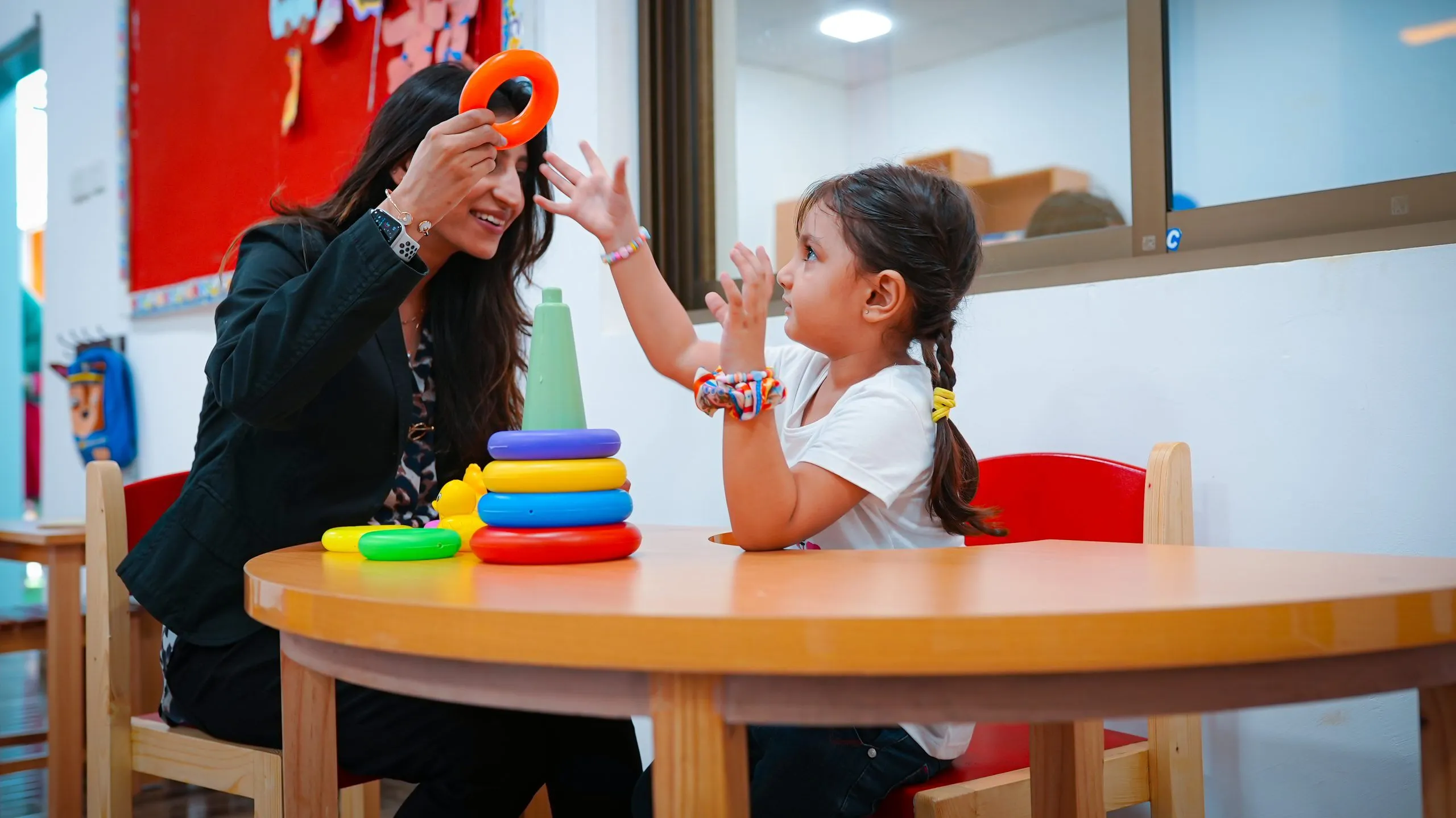 Therapist supporting a child during autism therapy session in Karachi