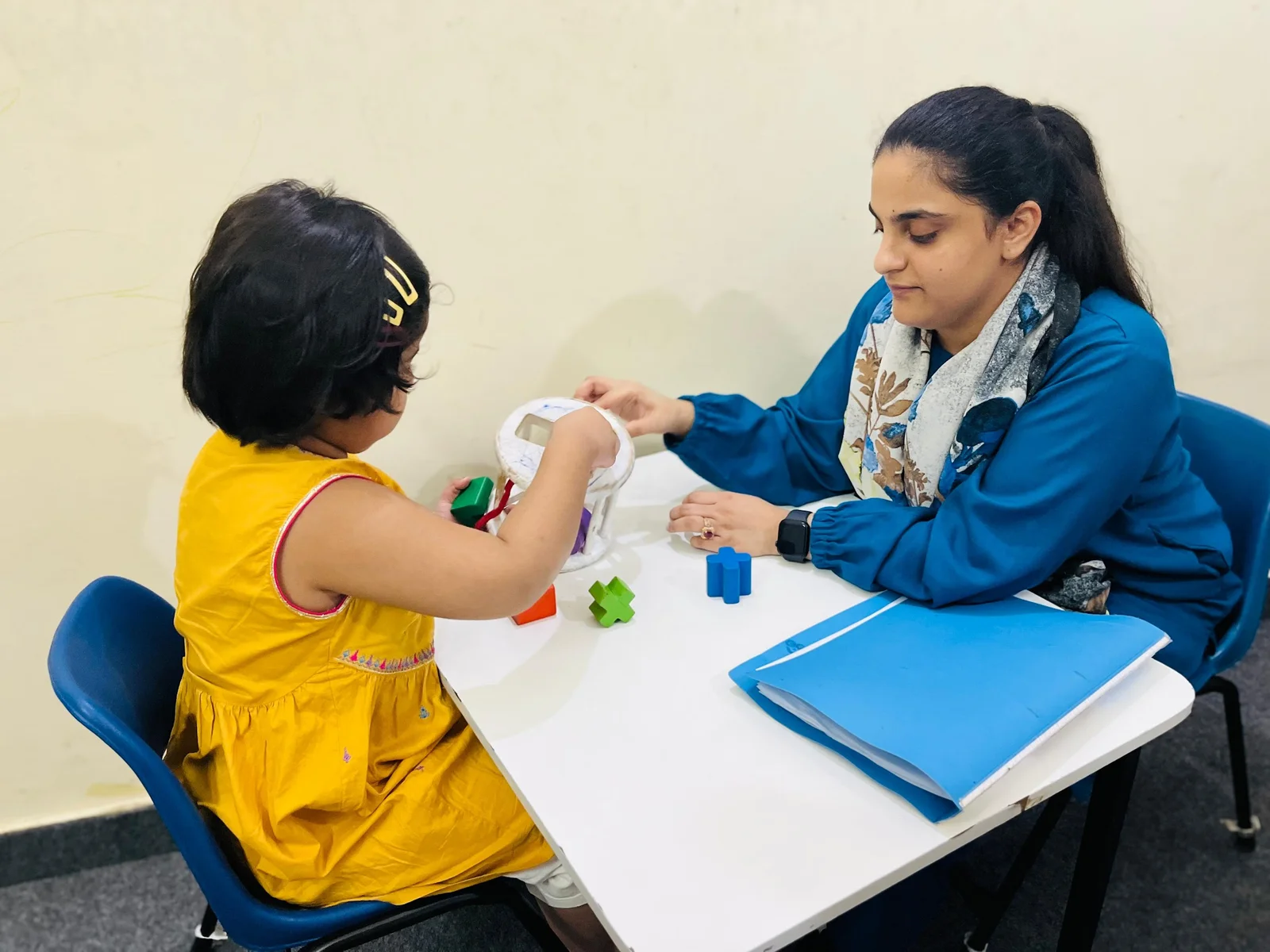 Bright sensory integration room with swings and soft lighting