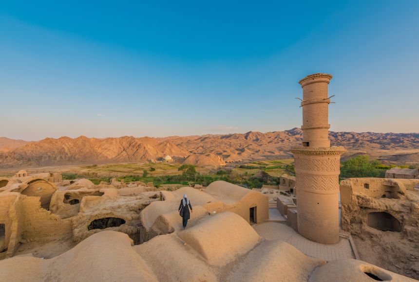 Kharanaq, Iran A tourist looks around the ancient city of Kharanaq, Iran. Towns such as these played a crucial role in the operation and success of the Silk Road.