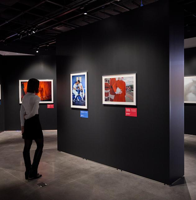 A person inside the "Red, White & Blue" exhibition studies framed photography on display