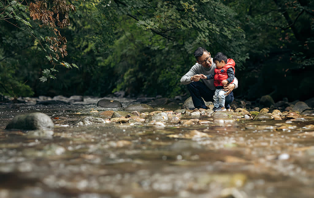 Chris Ho and his son playing by the creek