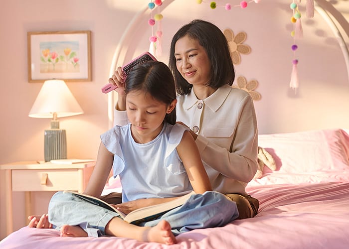 Carmen Hou brushing her daughter's hair