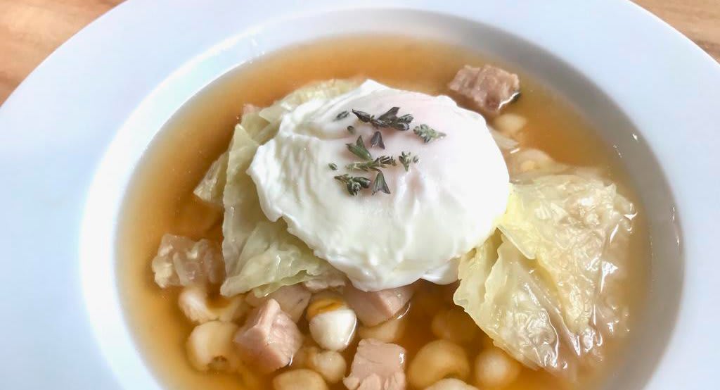 Maíz escairado con caldo de gallina y huevo escalfado