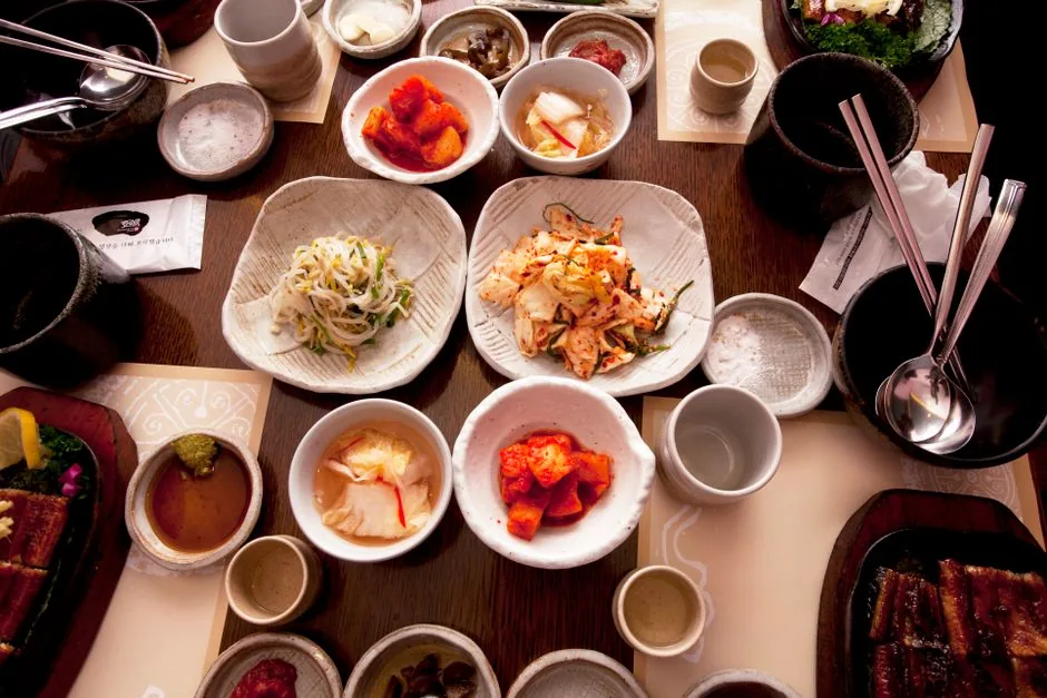 A Korean table set with rice, soup, spoon and chopsticks