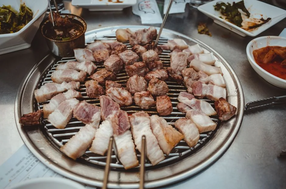 A Korean restaurant table set with main dish, side dishes, and grill